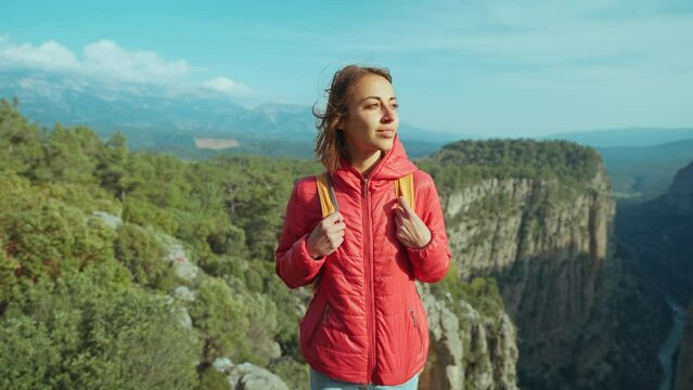 View point of Tazy Canyon. girl standing and admiring stunning scenery in mountains. Tourist woman hiker in red jacket on cliff against backdrop of gorge. Amazing Tazi Canyon, Turkey. Greyhound Canyon