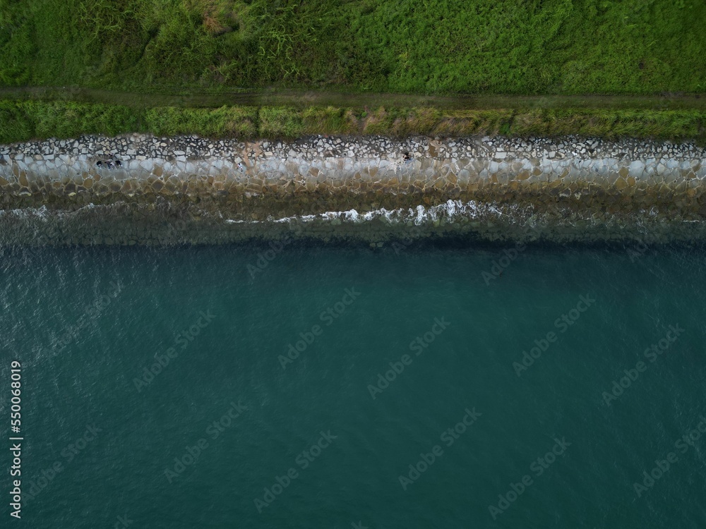 Wall mural aerial shot of a sea shore with ships waves sand