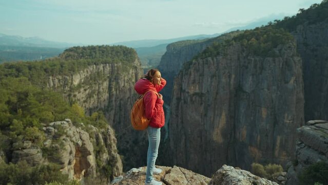 View point of Tazy Canyon. girl standing and admiring stunning scenery in mountains. Tourist woman hiker in red jacket on cliff against backdrop of gorge. Amazing Tazi Canyon, Turkey. Greyhound Canyon
