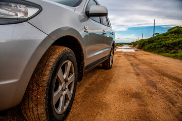 Fototapeta na wymiar SUV on a dirt road under a cloudy sky