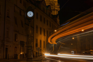 Clock and passing tram in the historic center of Prague