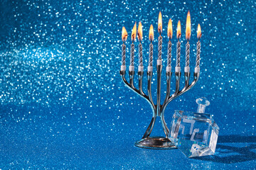 Jewish holiday Hanukkah background with menorah and dreidel with letters Gimel and Nun.