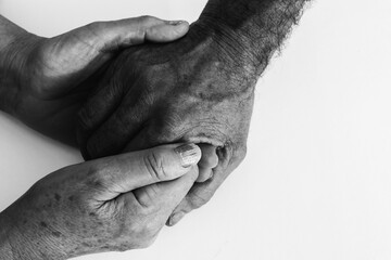 
Close-up of senior's hands resting on white isolated background with space for text.