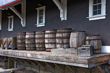 A row of old wooden barrels on a loading dock