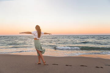 Fototapeta na wymiar Happy woman enjoying beautiful sunset on the beach