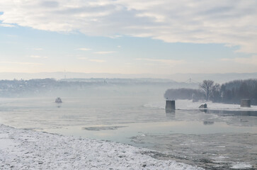 The bank of the Danube river covered with snow. Danube River covered with snow and ice. Frozen and snow-covered waterway of Danube river below Petrovaradin fortress, Vojvodina, Novi Sad, Petrovaradin,