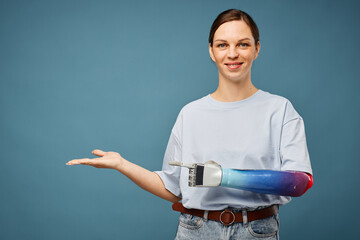 Cheerful young woman with bionic arm showing new project