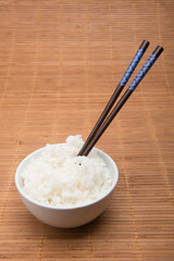 rice bowl with chopsticks on bamboo tablecloth