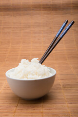 rice bowl with chopsticks on bamboo tablecloth