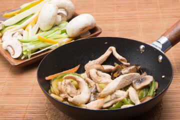 mushroom wok with vegetables on a table with a bamboo tablecloth