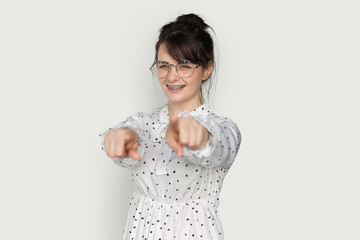 Happy girl wearing eyeglasses pointing with fingers at camera isolated over white background. Fashionable style. Positive person. White background. Good vibes