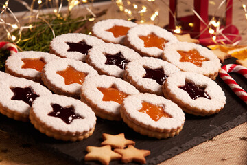 Handmade Christmas cookies against a backdrop of glowing lights. Linzer Cookies. Holiday baking and decor for Christmas and New Year