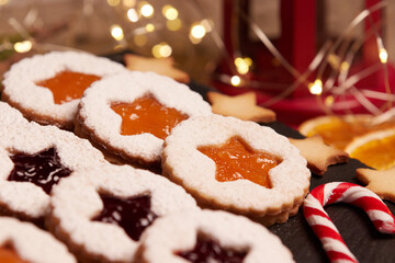 Handmade Christmas cookies against a backdrop of glowing lights. Linzer Cookies. Holiday baking and decor for Christmas and New Year