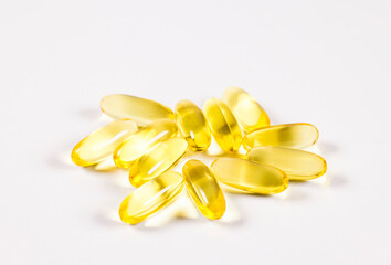 Yellow scattered pills on white background. Сapsules on white background.