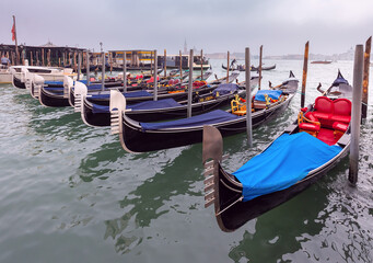 Traditional gondolas at the pier with the island of San Maggiore in the background.