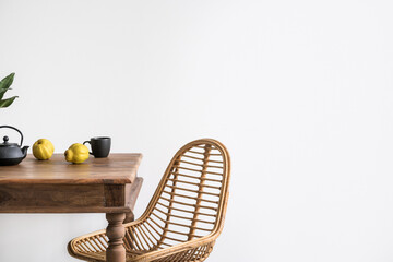 Boho interior with rattan chair near wooden dining table © brizmaker