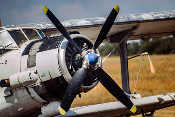 Aircraft propeller against the background of a yellow field and green trees close-up