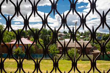 view of a small provincial town through a lattice of the fortress gates