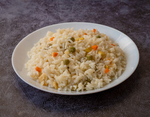 Vegan rice with vegetables, shot from above on a black background