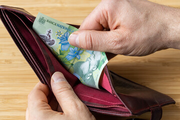 Hand takes money out of wallet, Romania banknotes, Economic and financial concept, rising prices,...