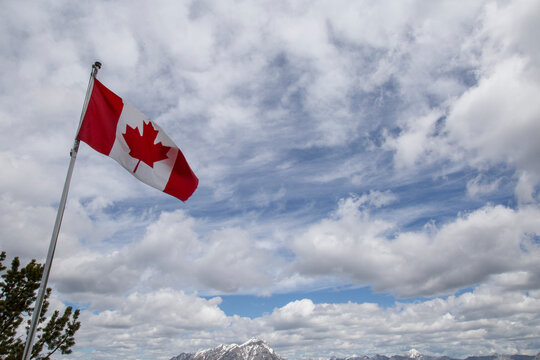 Low angle view of Canadian Flag against cloudy sky