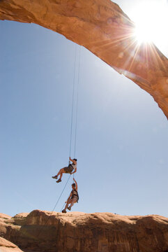 Two women rappelling from an arch near Moab, Utah.