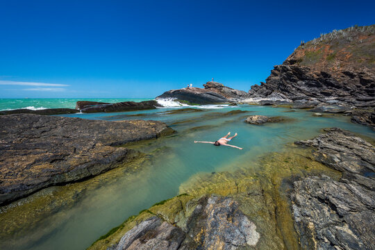 Man floating on water on rocky shore in Buzios, Rio de Janeiro, Brazil