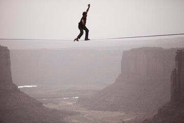 Andy Lewis working on a world record highline, three hundred and forty feet long, at the Fruit Bowl in Moab, Utah, USA.