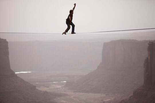 Andy Lewis working on a world record highline, three hundred and forty feet long, at the Fruit Bowl in Moab, Utah, USA.