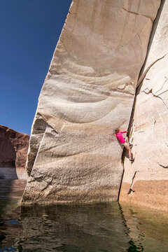 Woman climbing steep cliff, Utah, USA