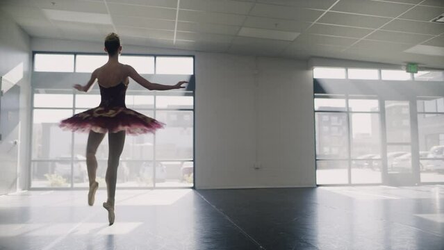 Tracking shot of ballerina practicing spinning in dance studio / Lehi, Utah, United States