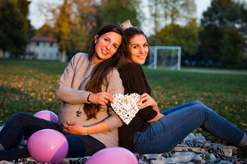 two women sitting on a bench in park