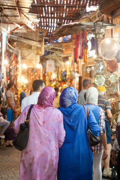 Two muslim moroccan women wearing the traditional dress going shopping in the suk /medina of Marrakesh. Morocco, North Africa