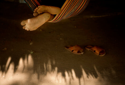 Detail of feet of a man sleeping in a hammock in Tayrona Park, Colombia.