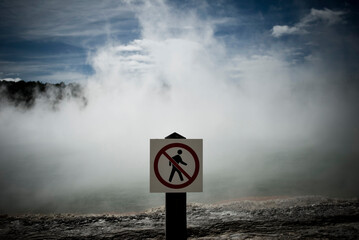 A 'no walking' sign stands in front of the bubbling Champagne Pool at Wai-o-tapu Thermal Wonderland in New Zealand.