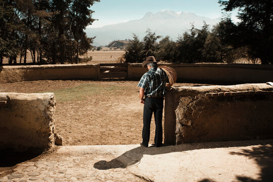 A man with a lasso on his shoulder stands in an exercise ring for horses at Hacienda San Andres, Estado de Mexico, Mexico