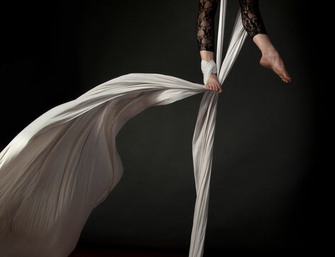aerial dancer feet suspended in white fabric