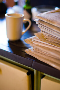Newspaper and coffee mug on old cast iron stove.