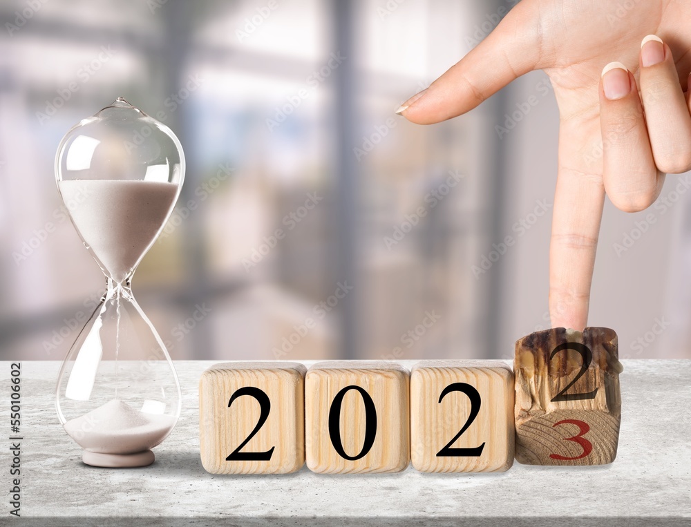 Poster Wooden block and retro hourglass on desk