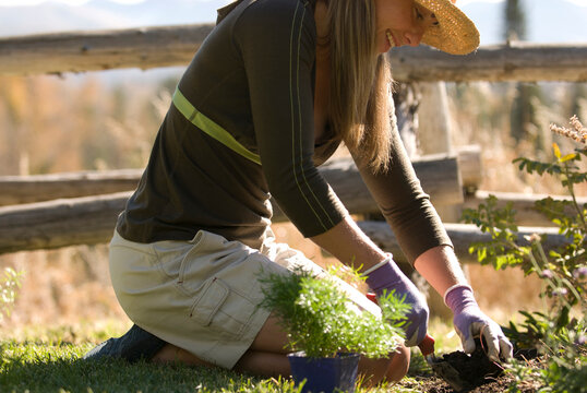 A young woman smiles while gardening in Jackson Hole, Wyoming.