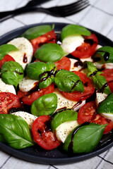 Italian signature caprese salad on a black plate.