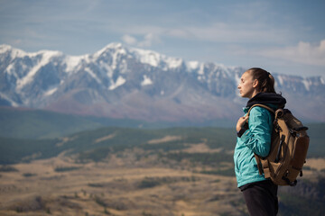 Naklejka na ściany i meble Lonely backpacker girl is trekking in the mountains
