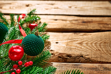 Christmas composition with green christmas ornaments and fir branches  on wooden table with copy space. Christmas and New Year greeting card. Minimal style.