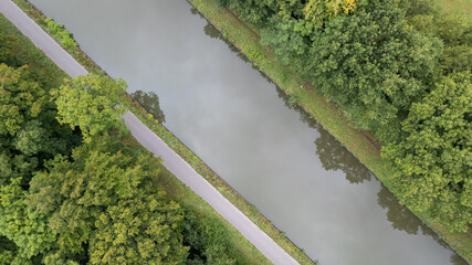 bird's eye view of canal in Rijkevorsel, Belgium, between forests and farm fields, aerial photo shot by a drone. High quality photo