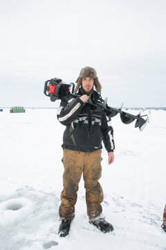 An angler poses with his automatic ice fishing driller machine at world&acirc;&euro;&trade;s largest ice fishing tournament in Minnesota.