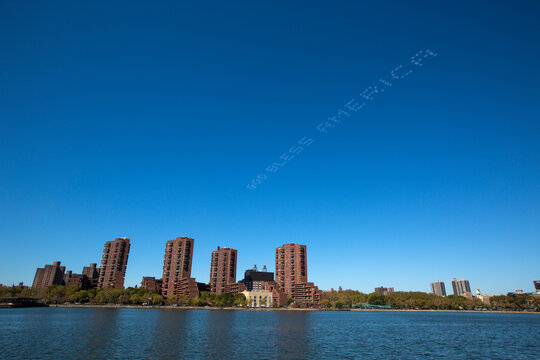 Patriotic skywriting over waterfront city skyline, New York City, New York, USA