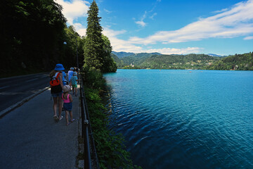 Family walking at embankment of beautiful Bled lake, Slovenia.