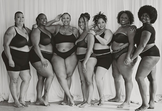 Black and White image of Seven Black women connecting and celebrating body positivity