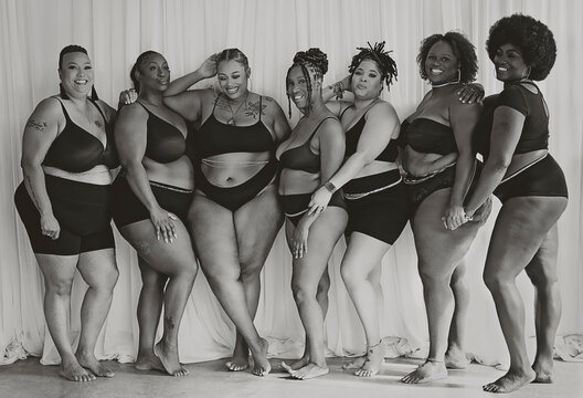 Black and White Image of  Seven Black women connecting and celebrating body positivity