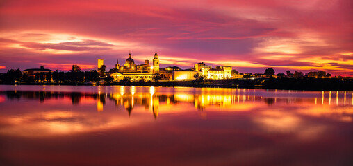 Fototapeta na wymiar Panoramic evening view of Mantua, Lombardy, Italy; scenic twilight skyline view of the medieval town reflected in the lake waters